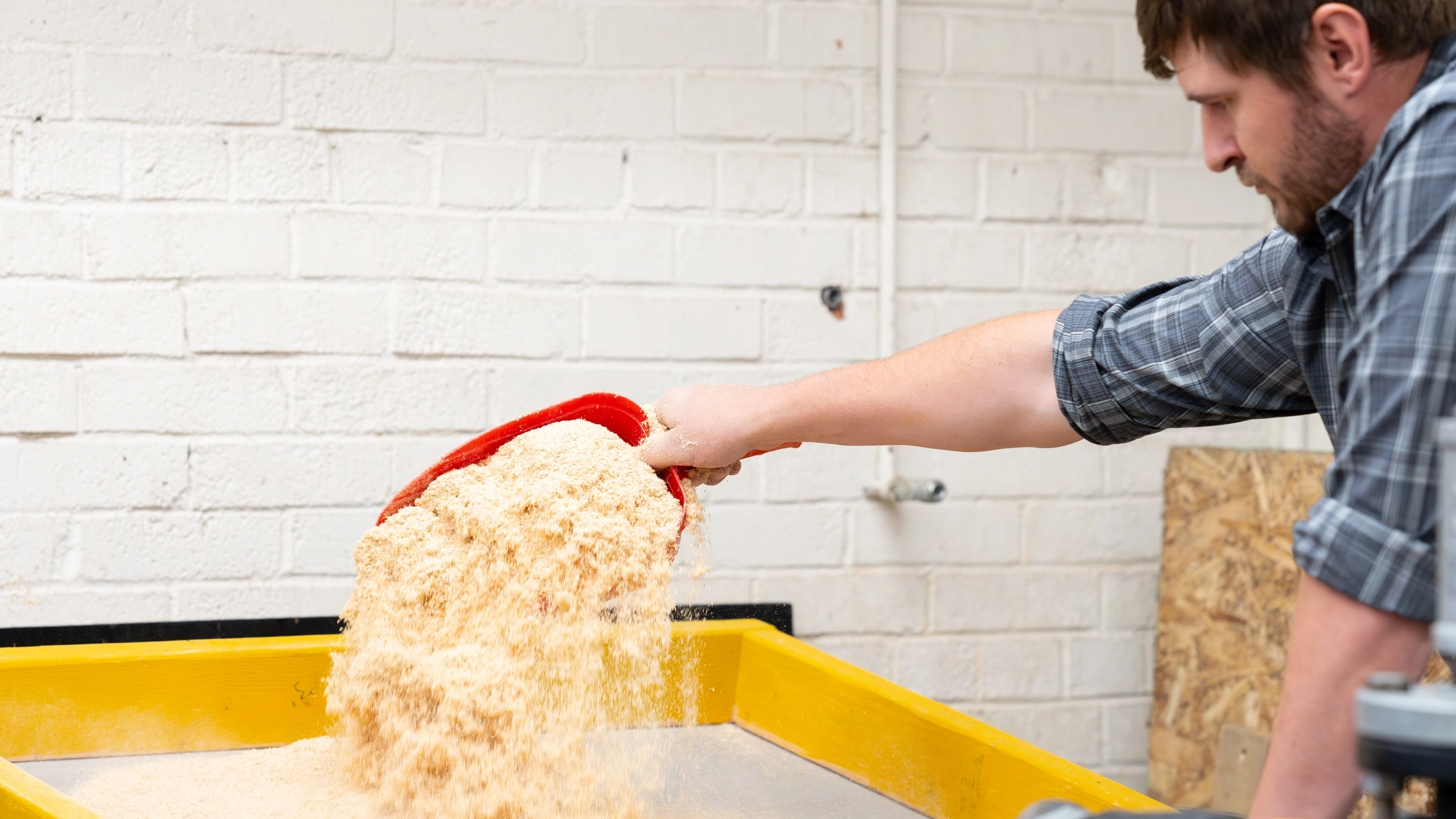 Student works with sawdust used in printing process.