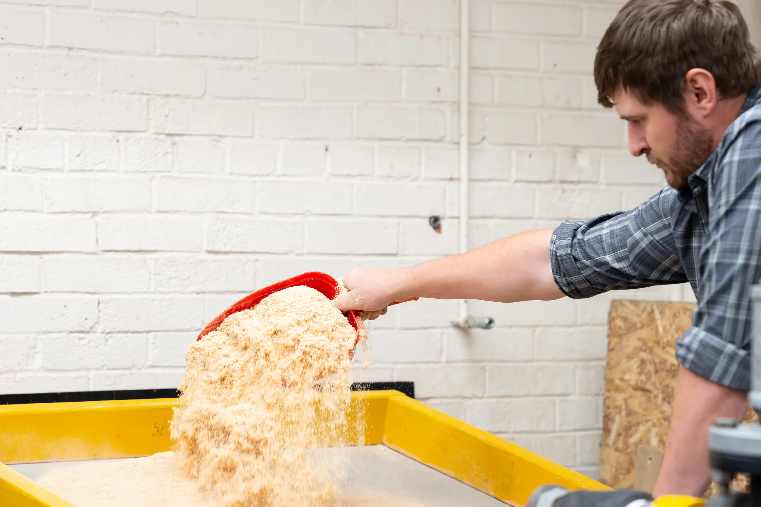 Student works with sawdust used in printing process.