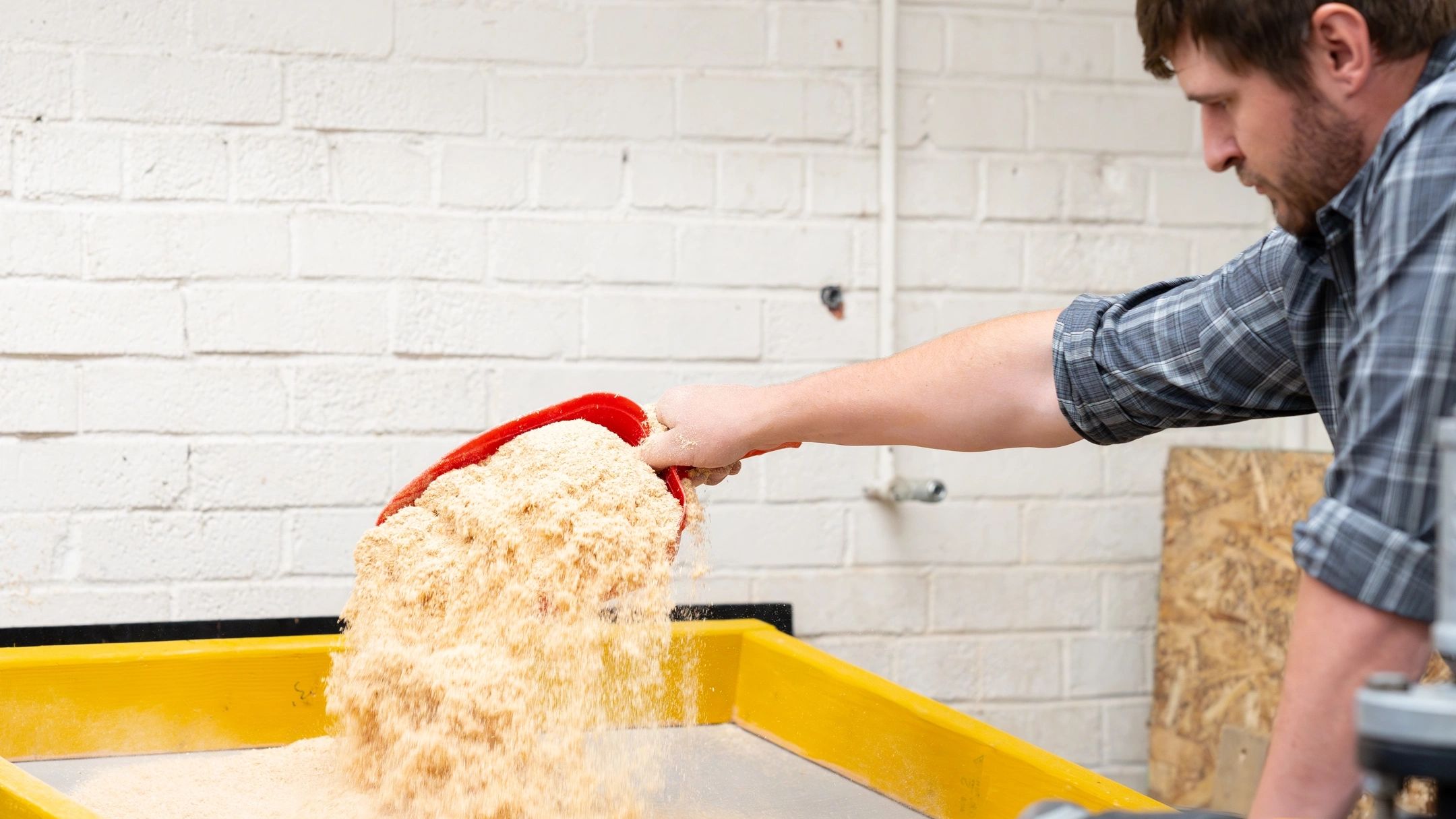 Student works with sawdust used in printing process.