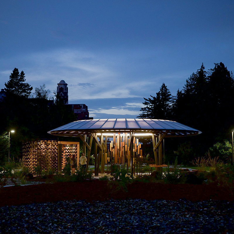 Vandal Healing Garden at night, with memorial gym in the background