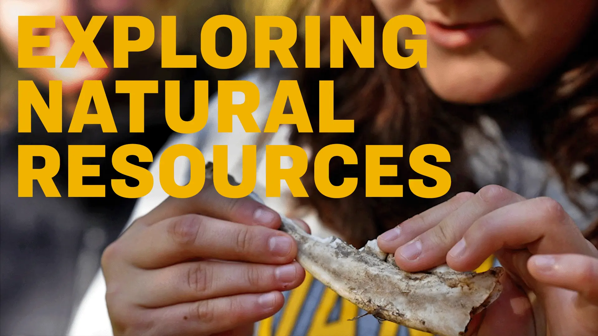 Hand holds a deer jaw bone, overlaid with the text "exploring natural resources."