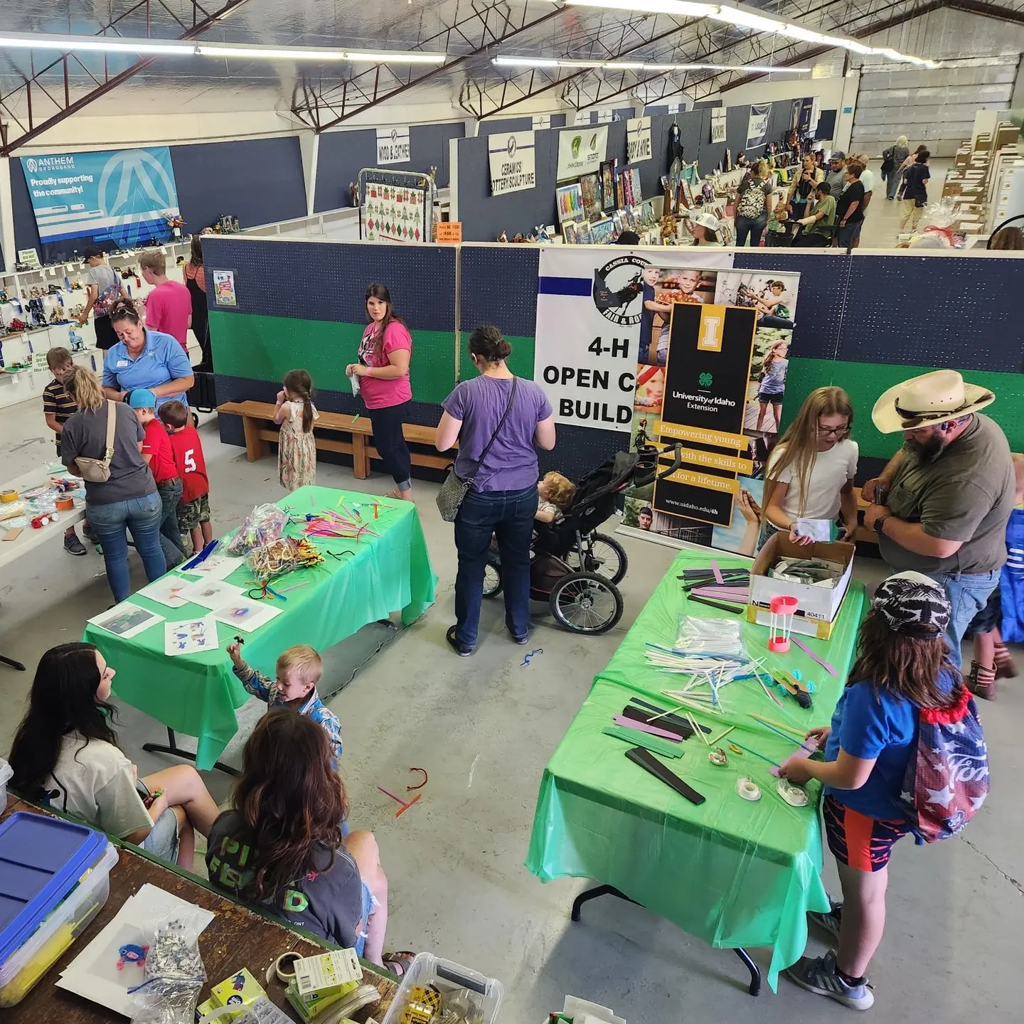 Fair attendees wander between fair tables.