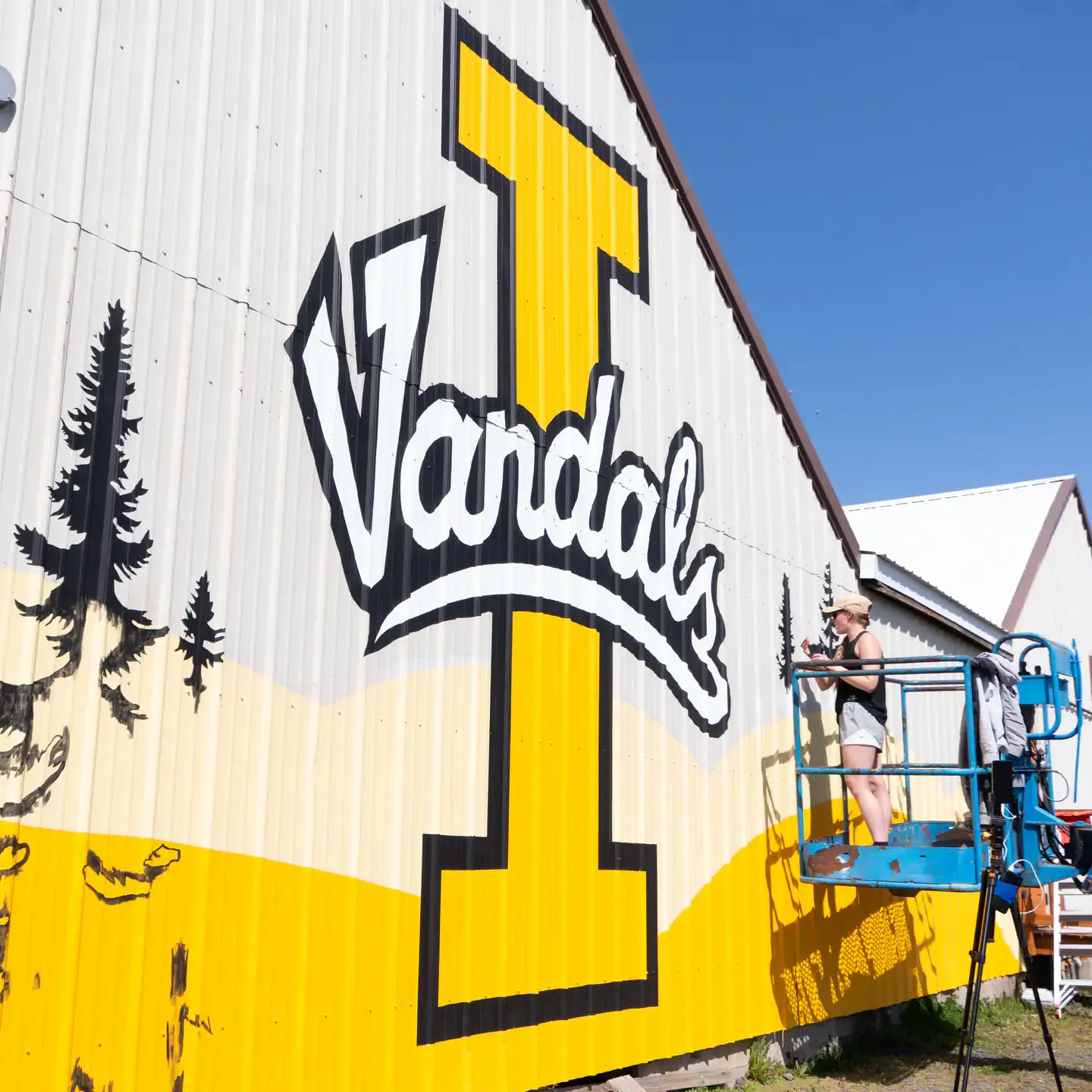 Alumna Mikaela Herrick paints a University of Idaho mural on the south wall of Forty Two bar and kitchen restaurant in Moscow, ID Thursday, April 24, 2025.