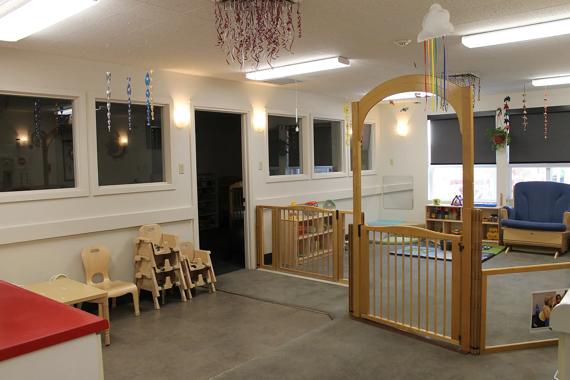 A small area with kitchenette, chairs and tables for infants.
