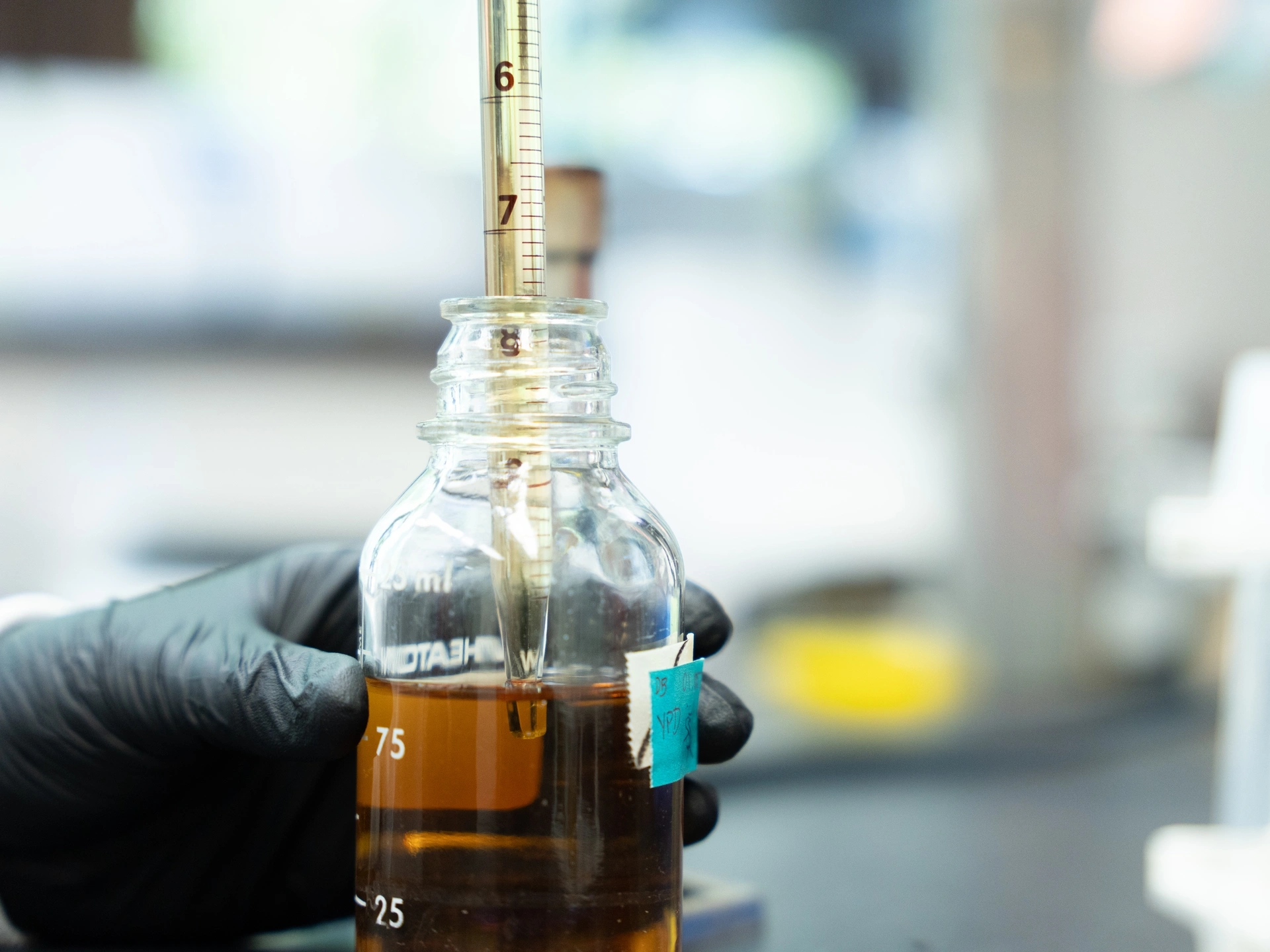 Brown liquid is pipetted into a Petri dish.