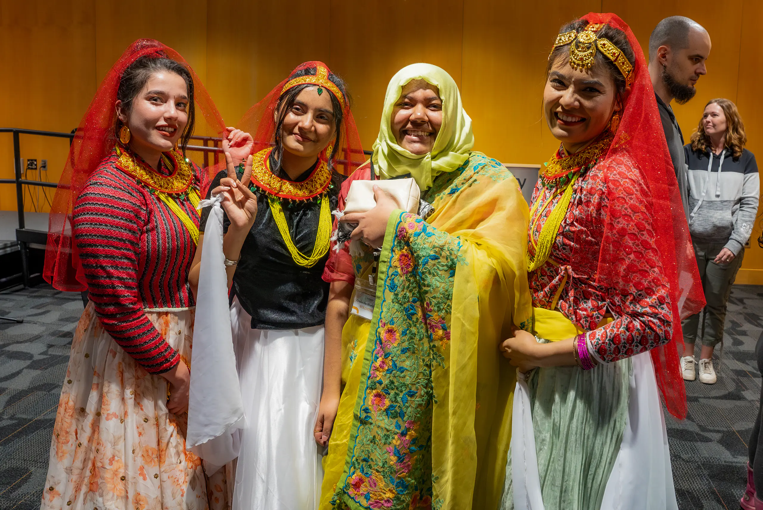 Four individuals wearing traditional costumes from their cultures