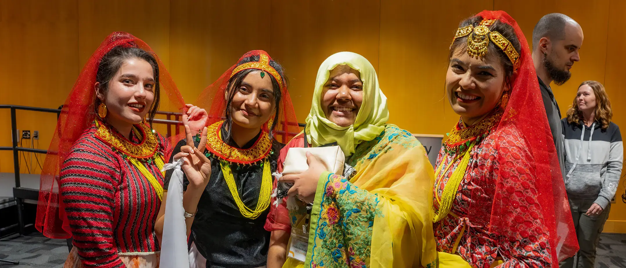 Four individuals wearing traditional costumes from their cultures