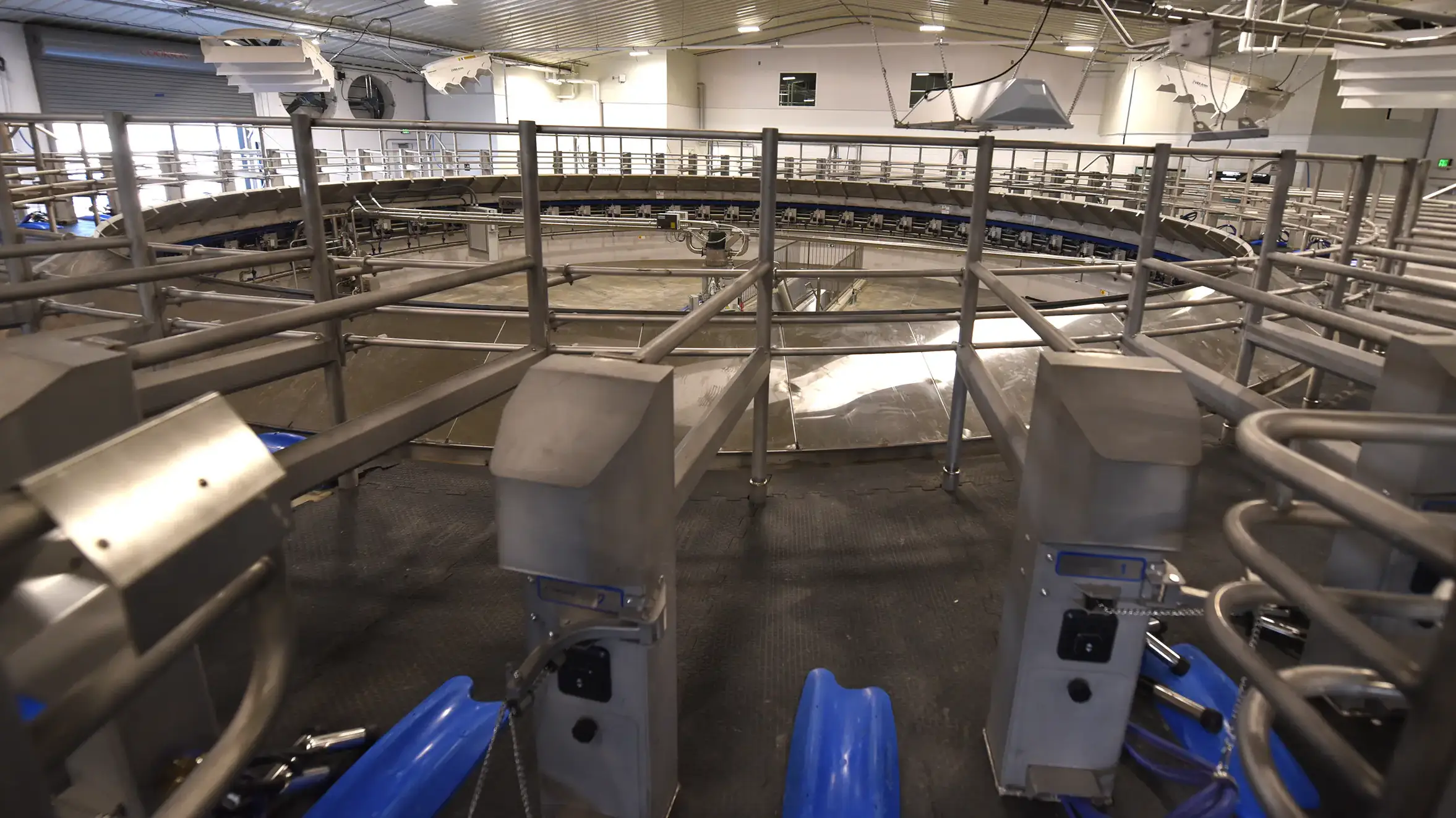 Interior of a circular automated facility with metal railings and equipment, likely part of a production or processing system.