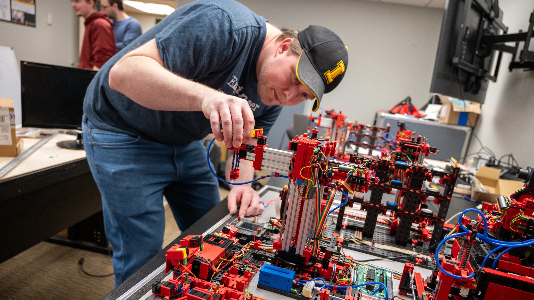 Dan Blanchette adjusts a LEGO piece in a programmable logic controlled mini-factory