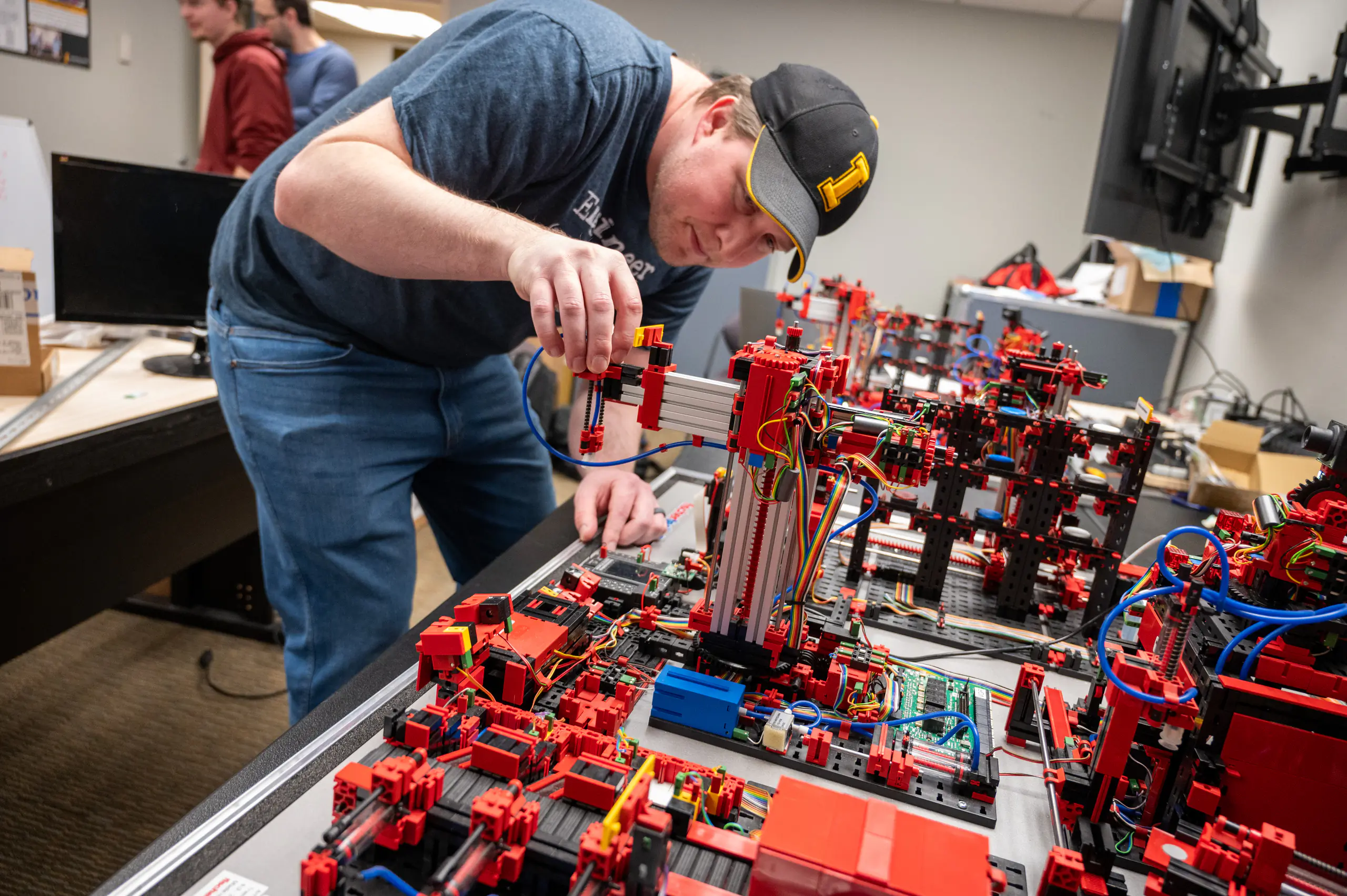 Dan Blanchette adjusts a LEGO piece in a programmable logic controlled mini-factory