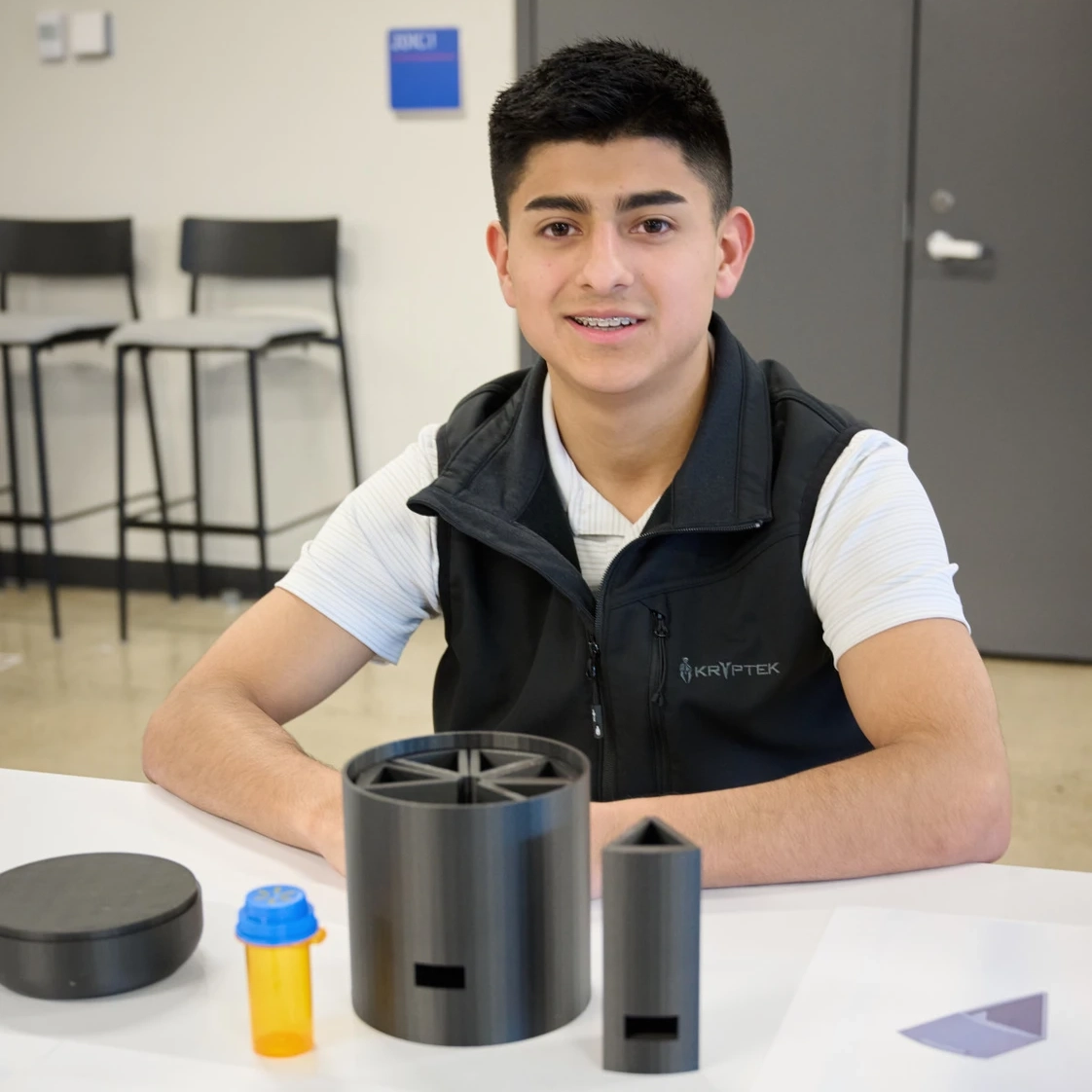 Ismael Valadez smiles with a device on the table in front of him