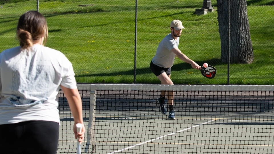 Students playing pickle ball on the Administration Building lawn tennis courts on University of Idaho campus in the spring.