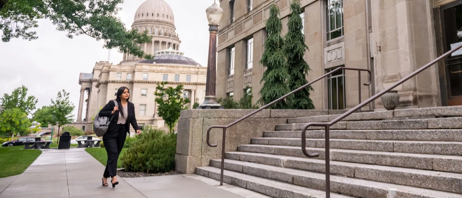 Woman walking outside in business attire near business buildings