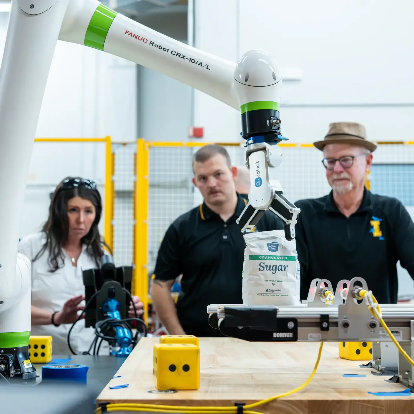 Engineering students and faculty are developing AI-driven automation solutions for Amalgamated Sugar to keep the plant's assembly line from breaking down while adding components to maintain moisture levels in sugar beets, helping the company improve productivity and optimizing both quality and quantity. Pictured from left are Ph.D. researcher Sarah Davis, computer science graduate student Hunter Hawkins, research faculty John Shovic.
