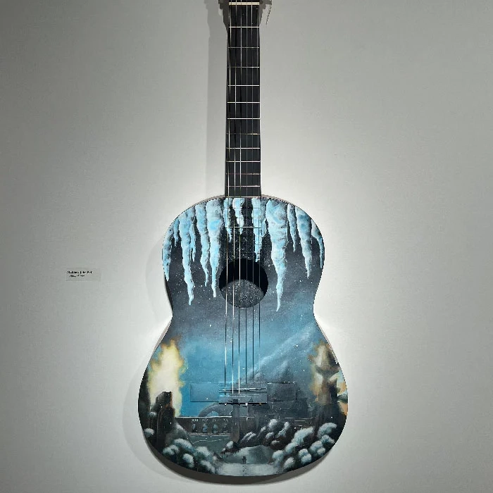 guitar painted with a frosty landscape scene with a castle in the distance