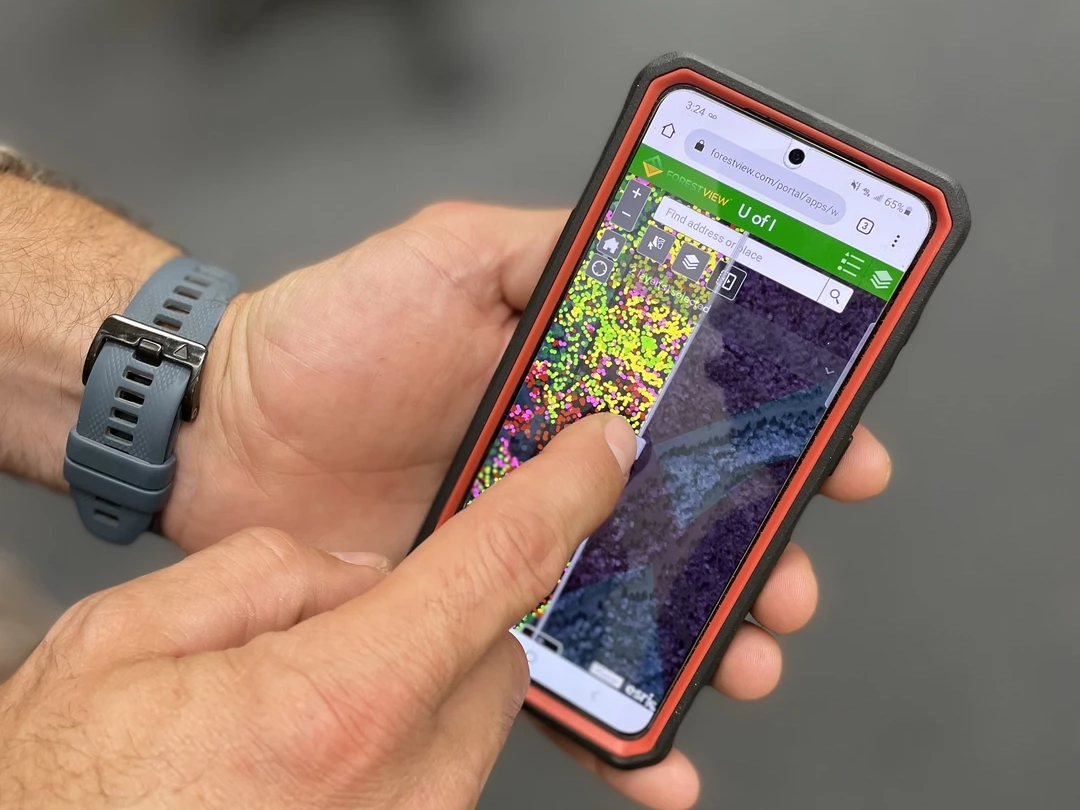 A pair of hands hold a cell phone with Lidar dots on it.