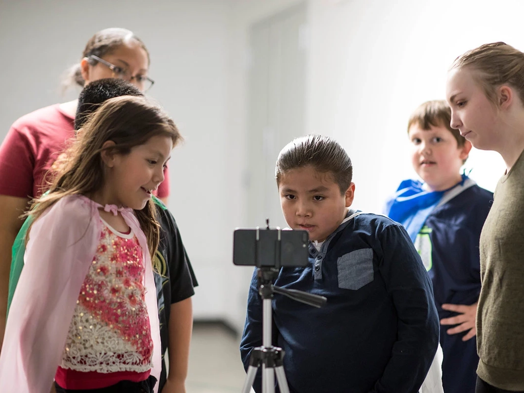 Students looks at a phone.