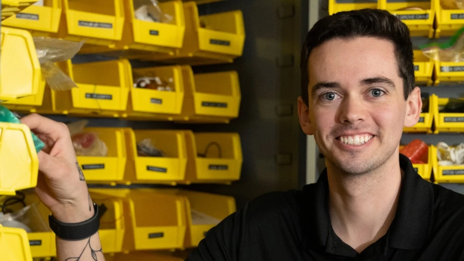 Leif Huender smiles in front of organized supplies