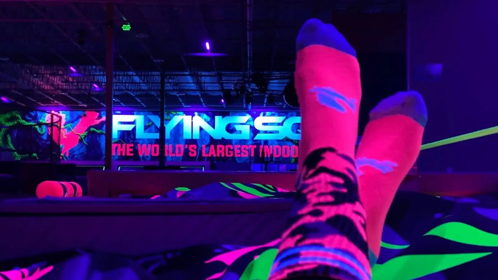A pair of neon pink socks glowing in the dark at the Flying Squirrel trampoline fun park