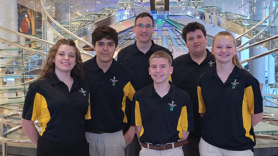 Six people smiling while wearing U of I polos