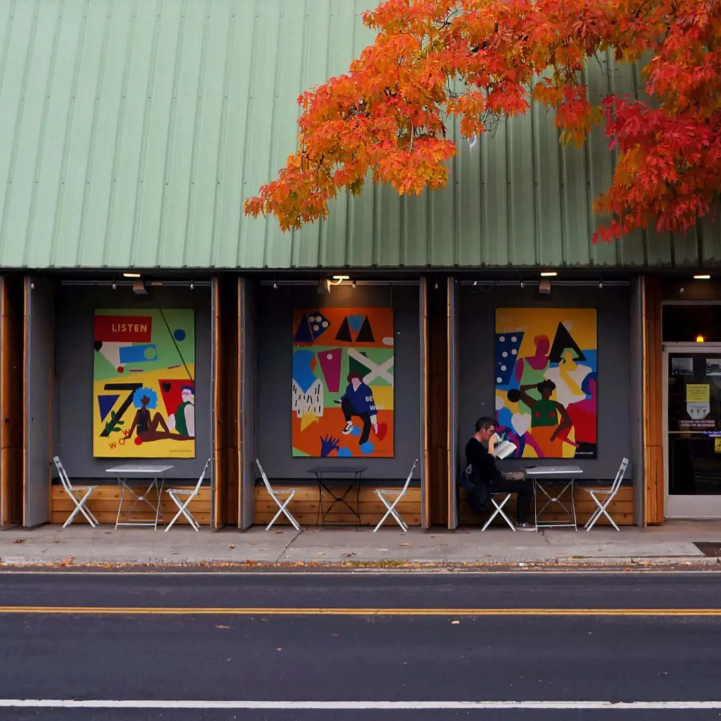 A building with colorful posters hanging on the side.