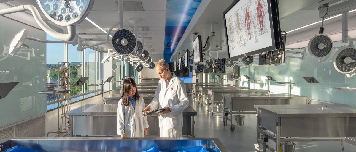 Student in medical training lab with professor