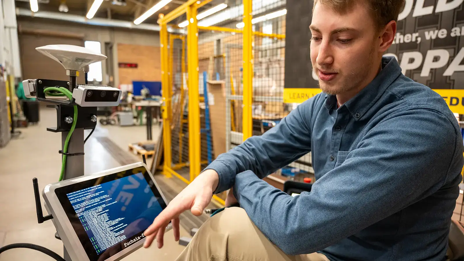 A student looking down and pointing at a screen