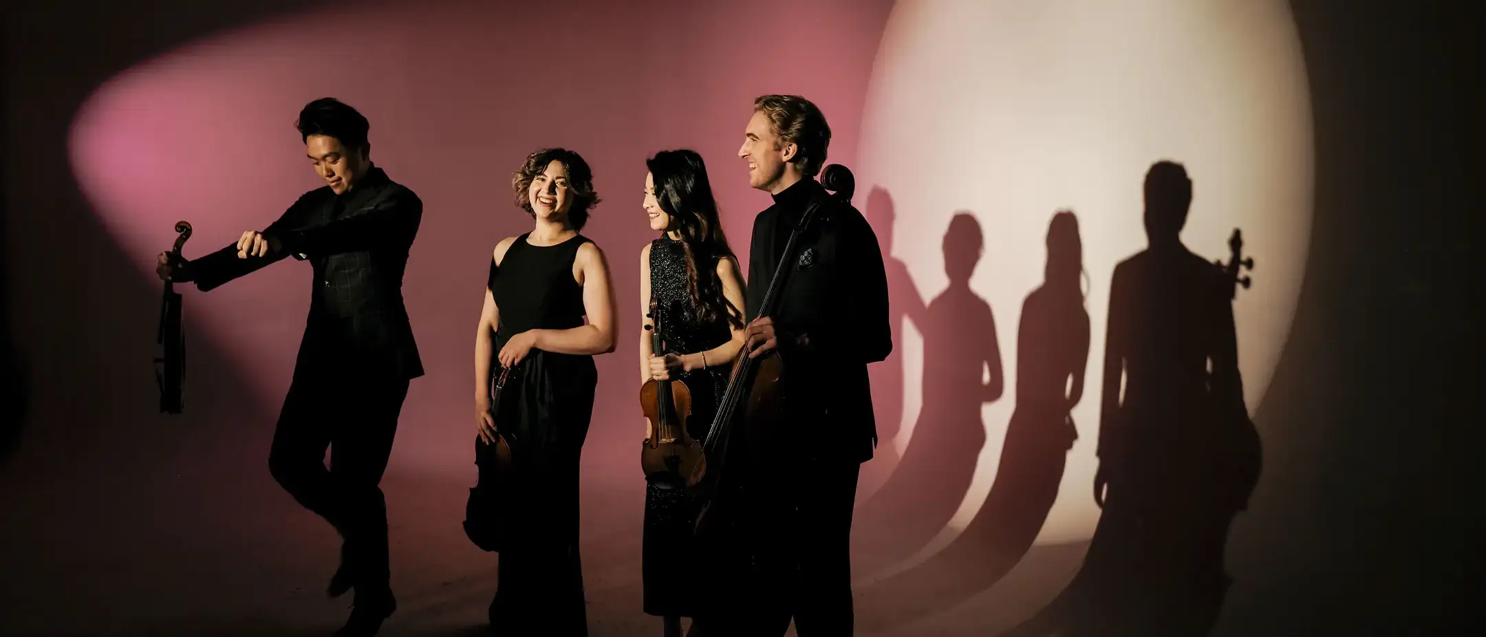 People playing instruments in front of a background.