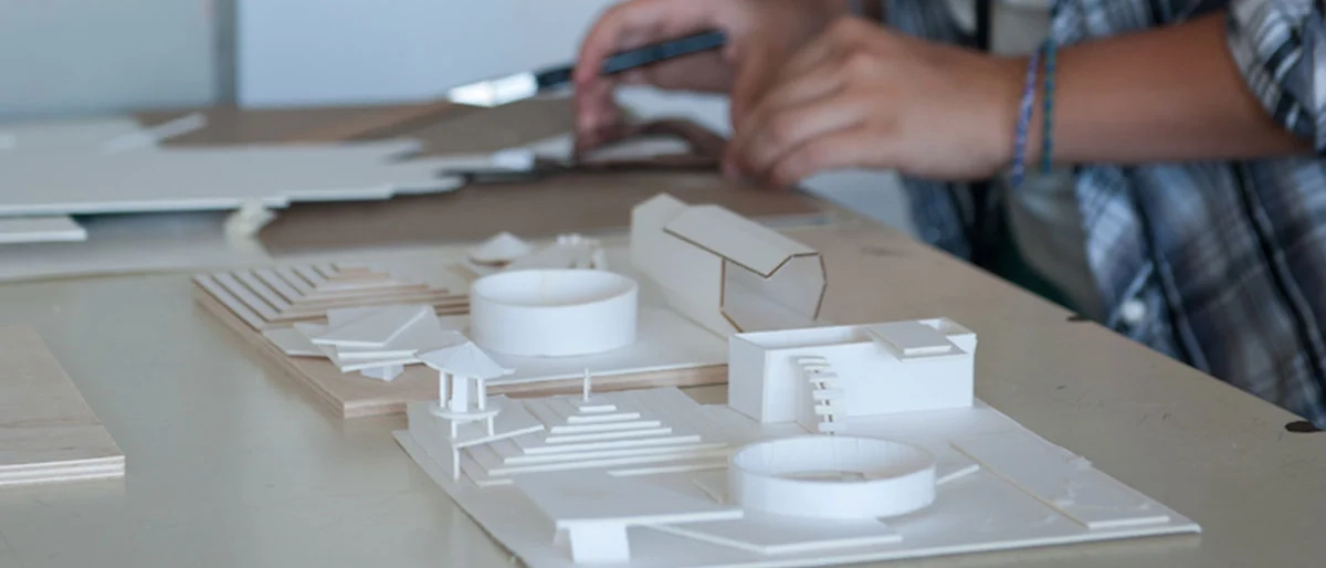 person building an intricate model of a building