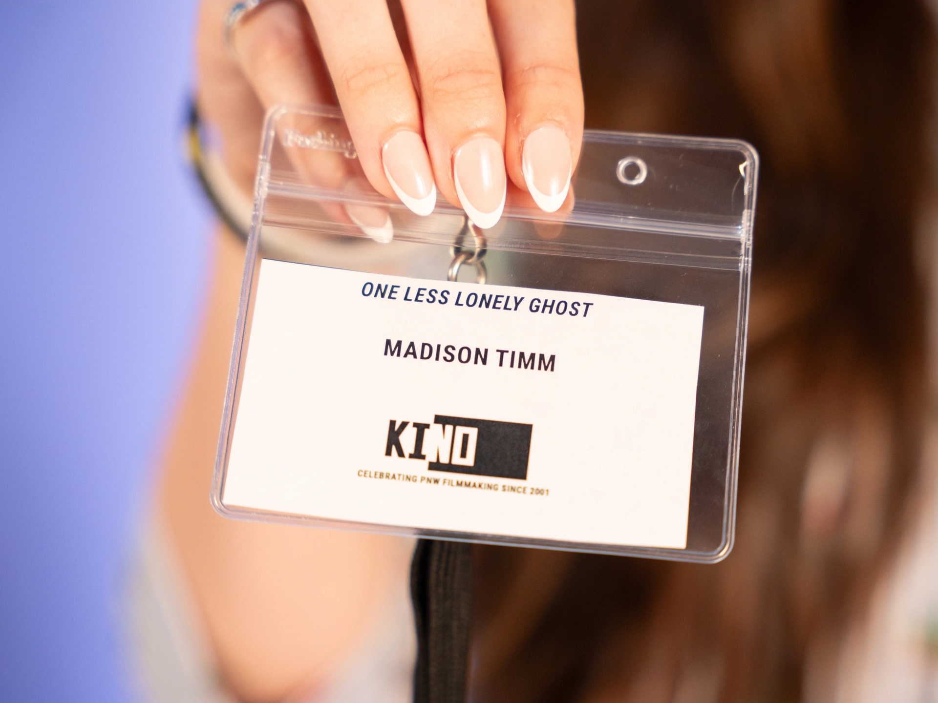 hand holds an event pass that reads One Less Lonely Ghost Madison Timm