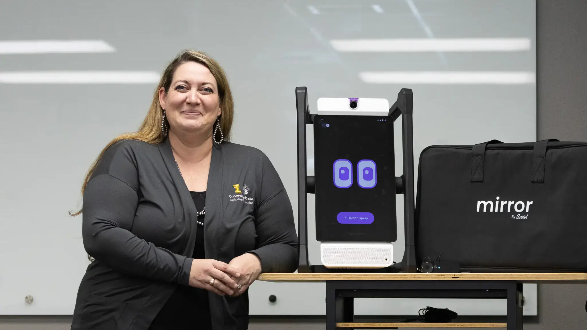 A robot with a digital readout screen containing blinking eyes is displayed by its case