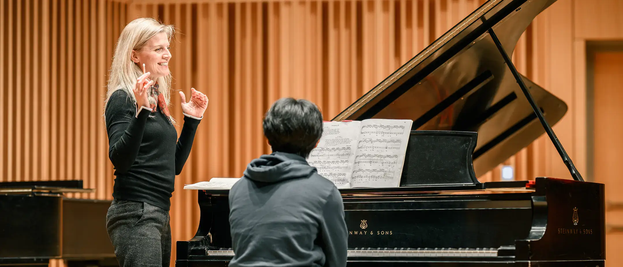 Woman and man at piano, performing