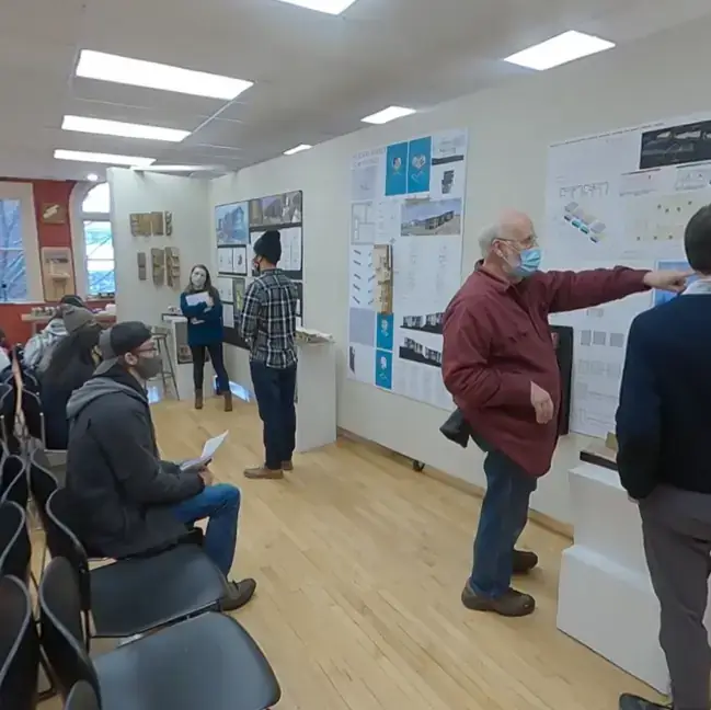 Adults in a room viewing large format printed architectural and design plans