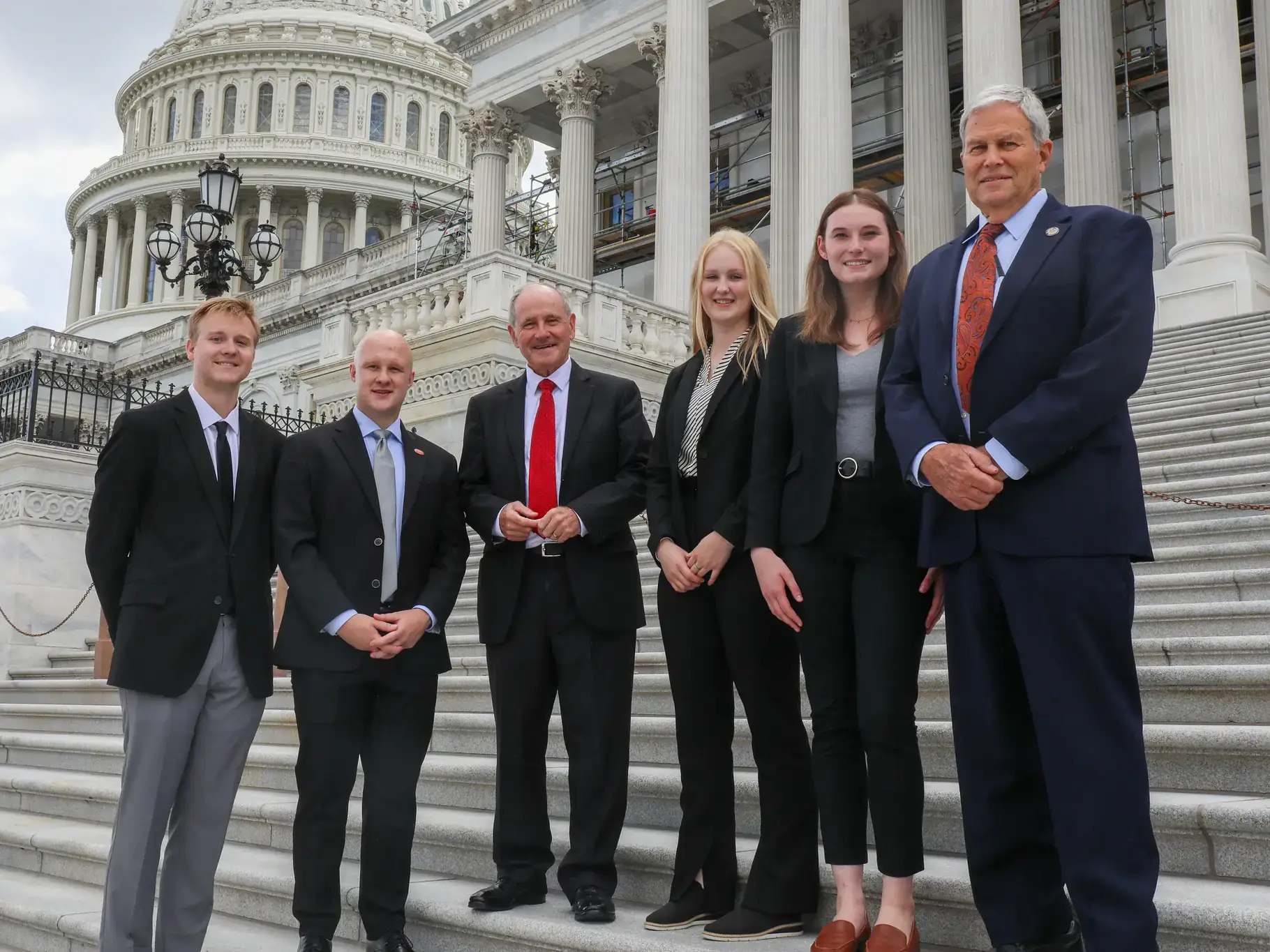 A group of people stand on the steps of the nation’s capital.