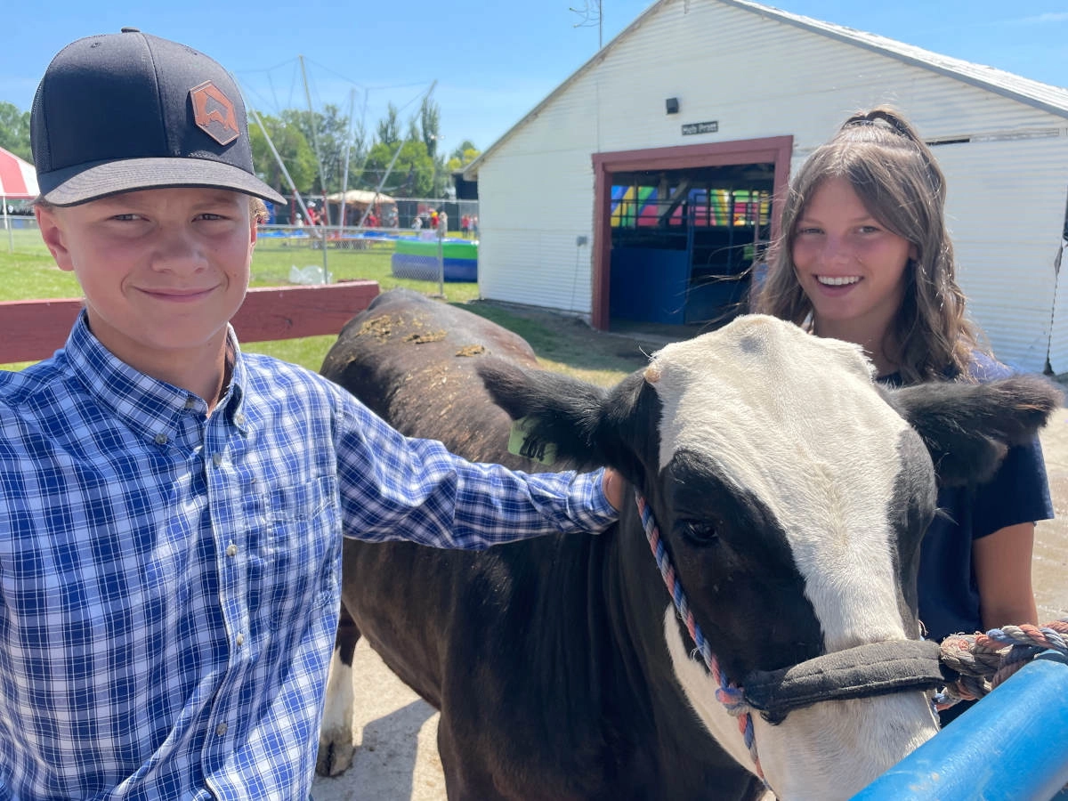 Two children next to a steer