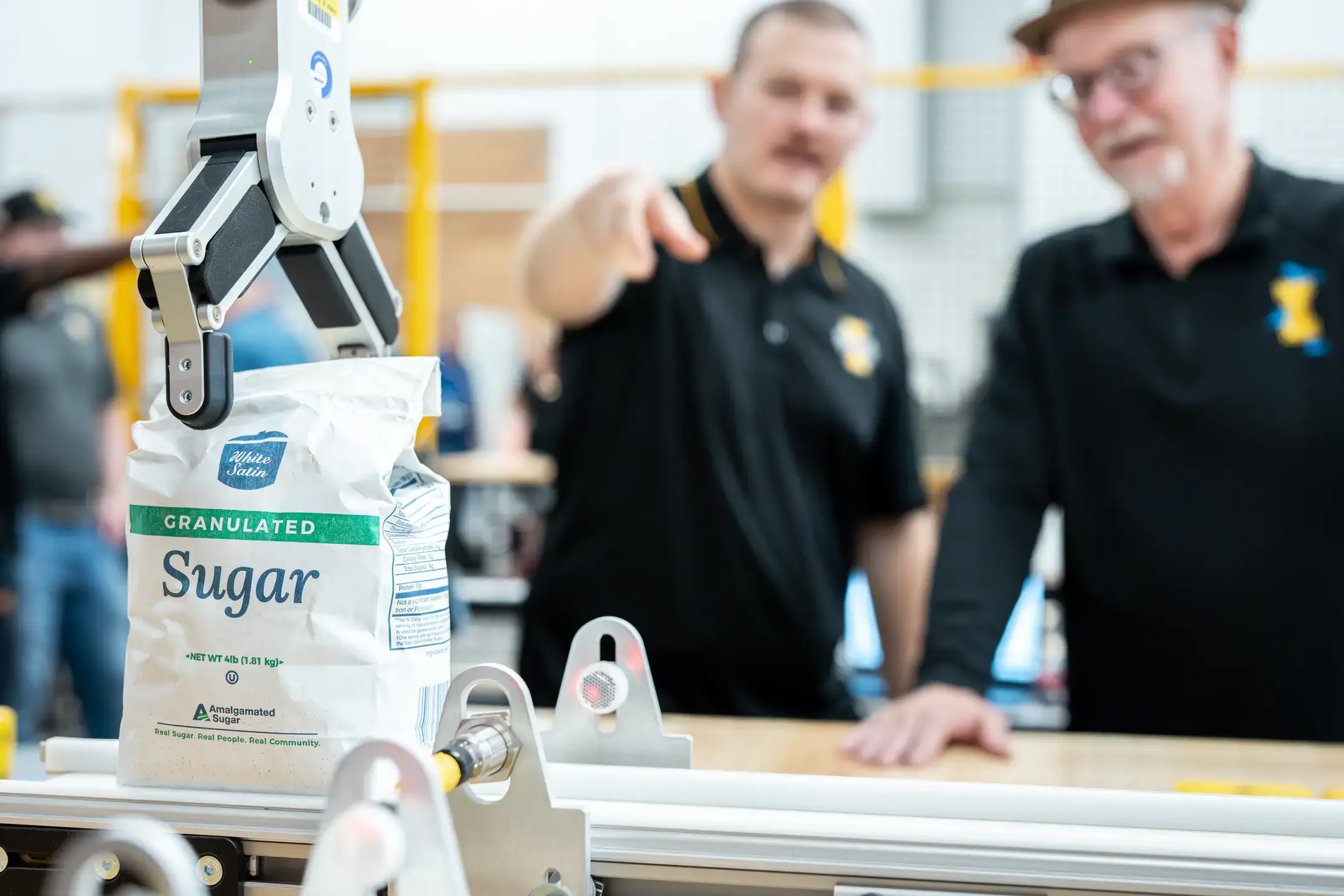 Engineering students and faculty are developing AI-driven automation solutions for Amalgamated Sugar to keep the plant's assembly line from breaking down while adding components to maintain moisture levels in sugar beets, helping the company improve productivity and optimizing both quality and quantity. Pictured are computer science graduate student Hunter Hawkins (left) and research faculty John Shovic (right).