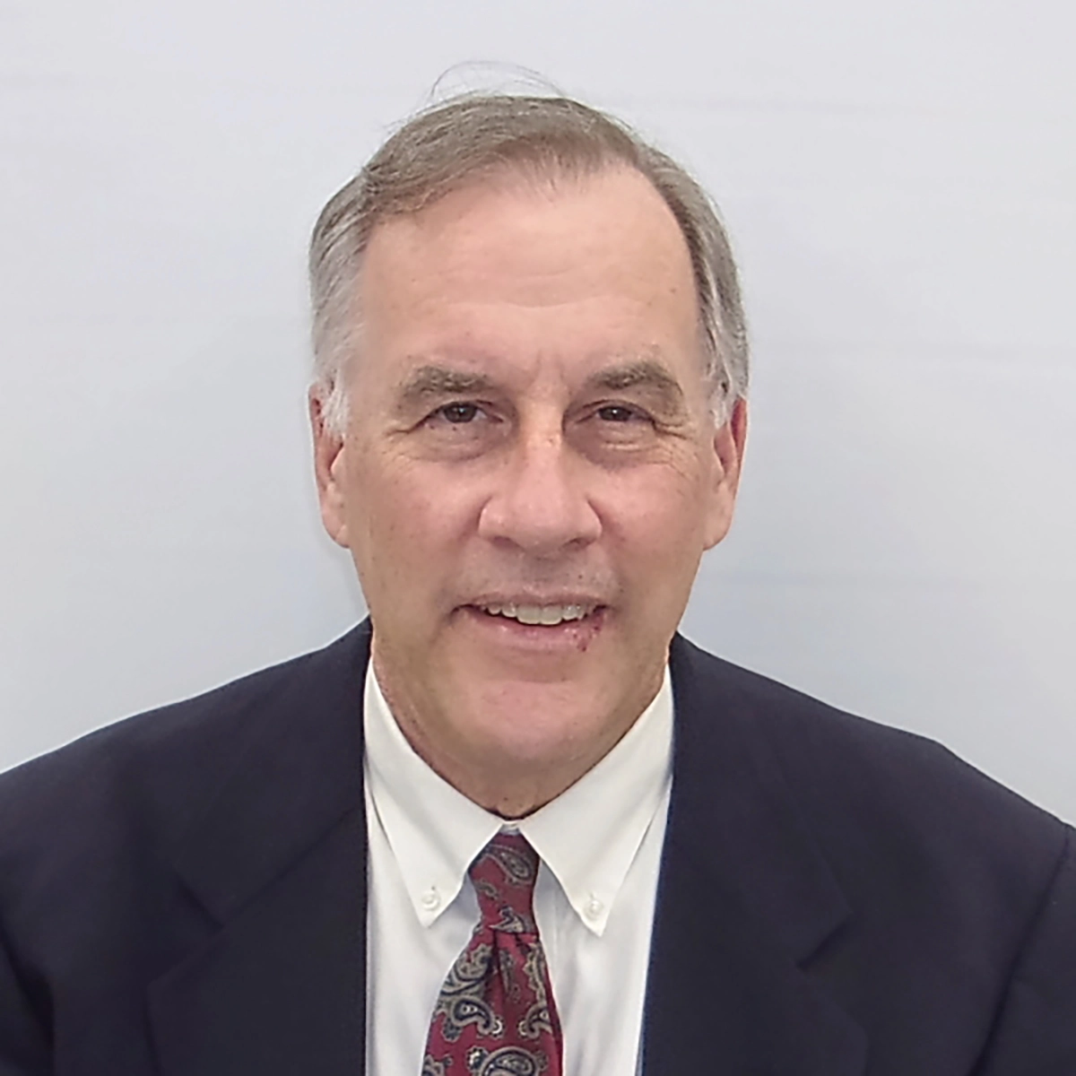 A headshot of a man in a suit