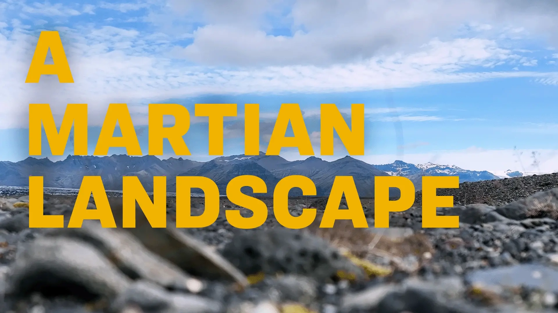 Rocky lava landscape with mountains in the background with text overlay: "A Martian Landscape".