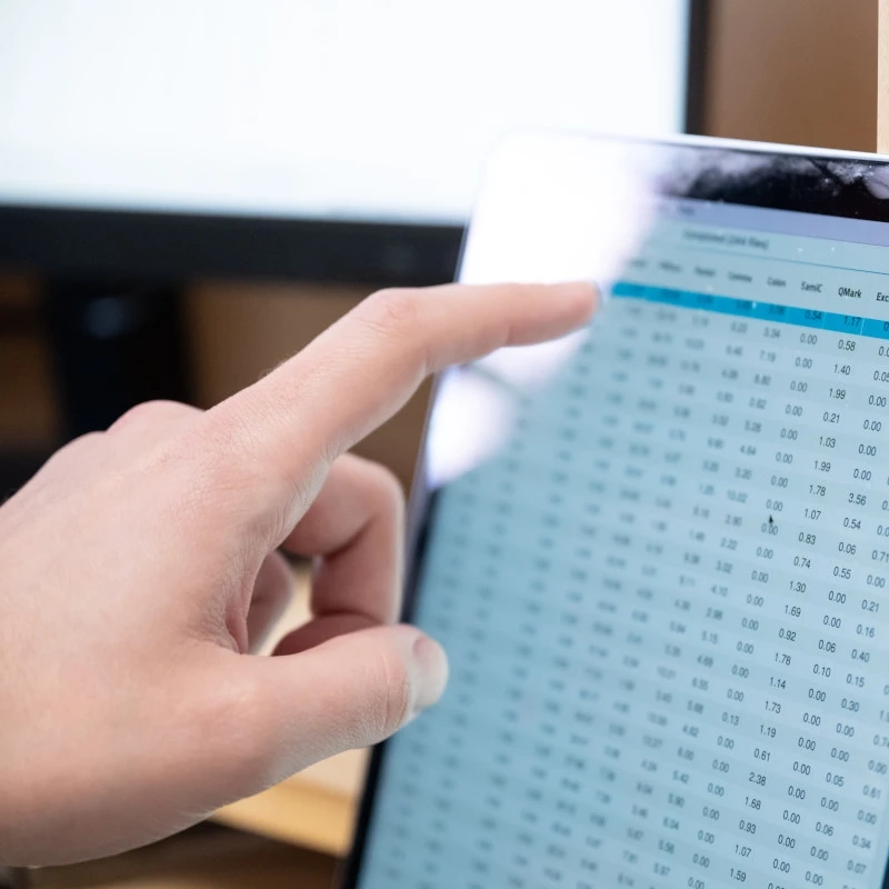 A hand points to a highlighted row in a data table