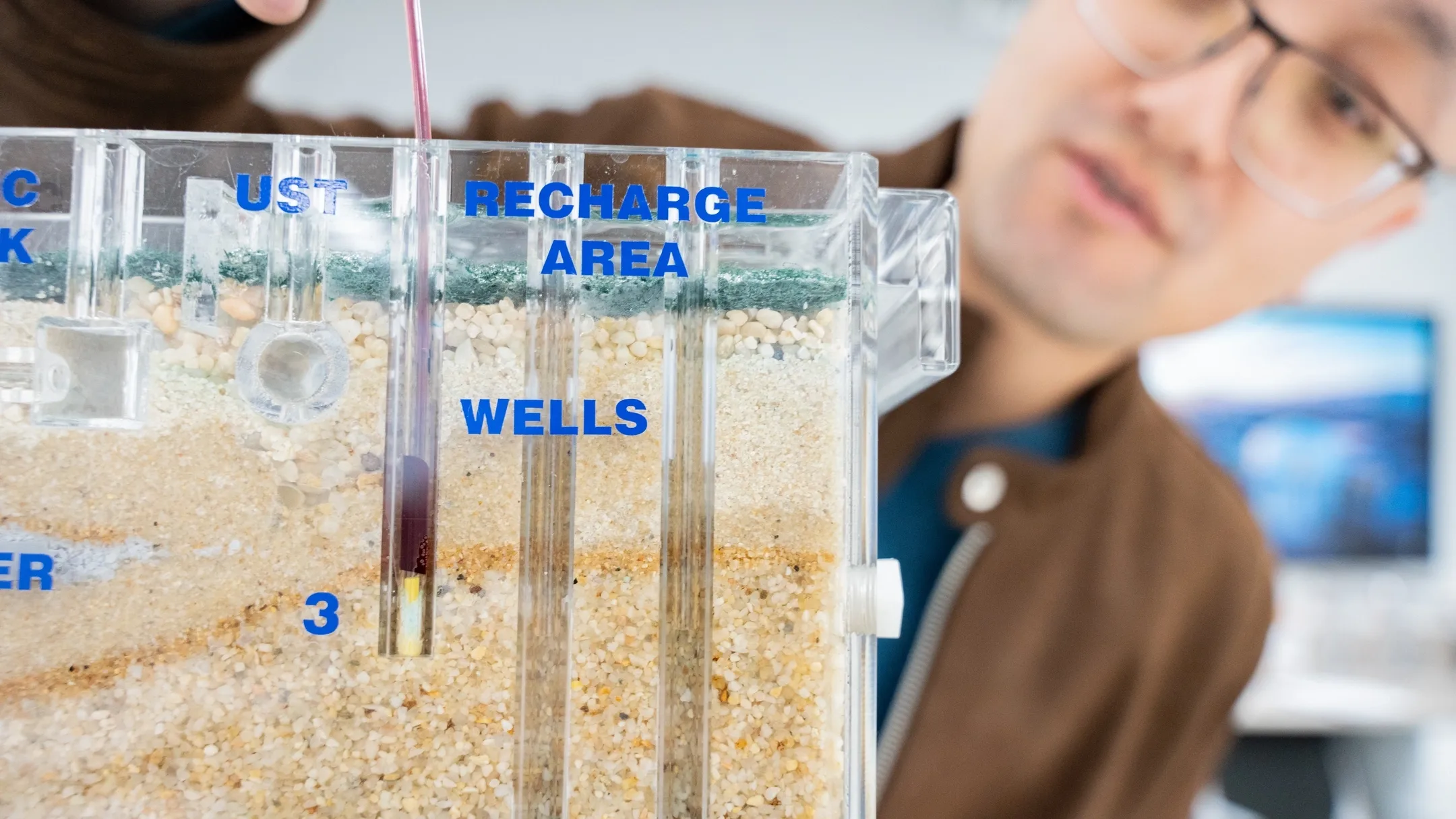 University of Idaho Earth and Spatial Sciences assistant professor Meng Zhao studies how trees use water in relationship to how much water is available to human beings in relationship with climate change. Here, he is demonstrating a sand and gravel ground water simulator
