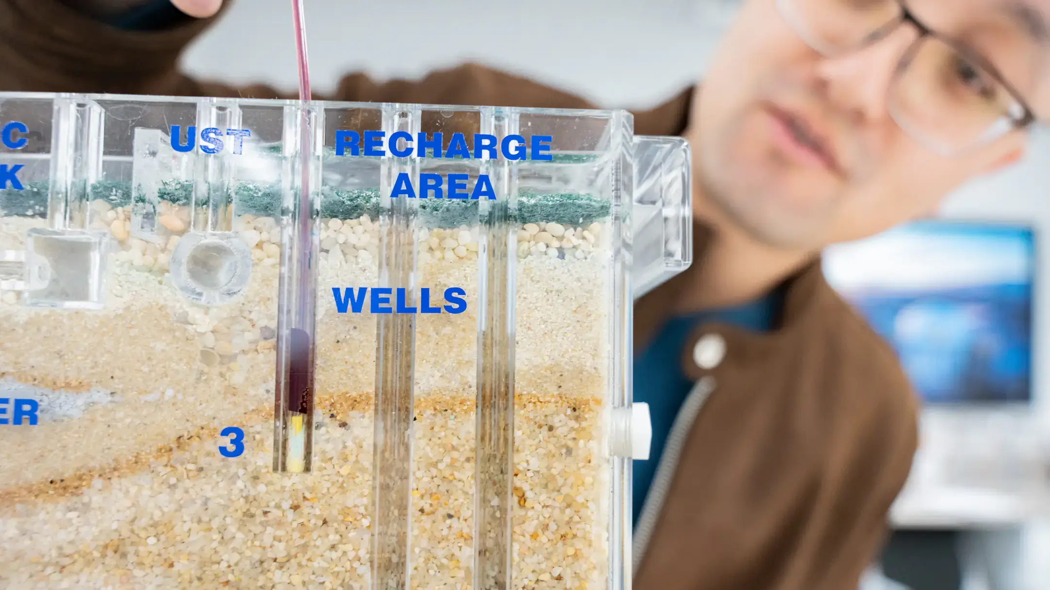 University of Idaho Earth and Spatial Sciences assistant professor Meng Zhao studies how trees use water in relationship to how much water is available to human beings in relationship with climate change. Here, he is demonstrating a sand and gravel ground water simulator