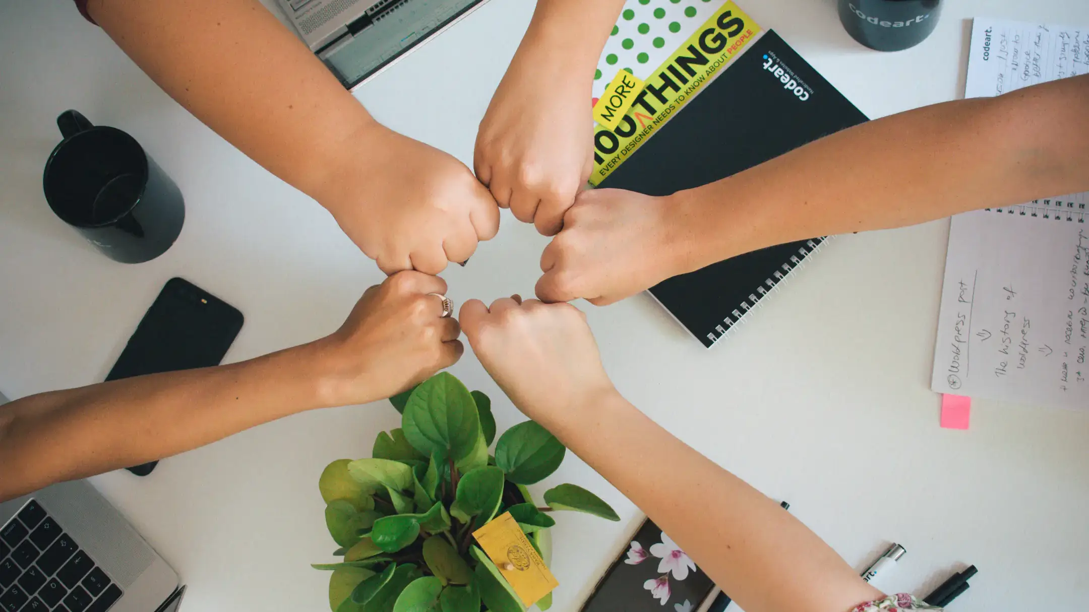 Youth fist bumps in the center of desk