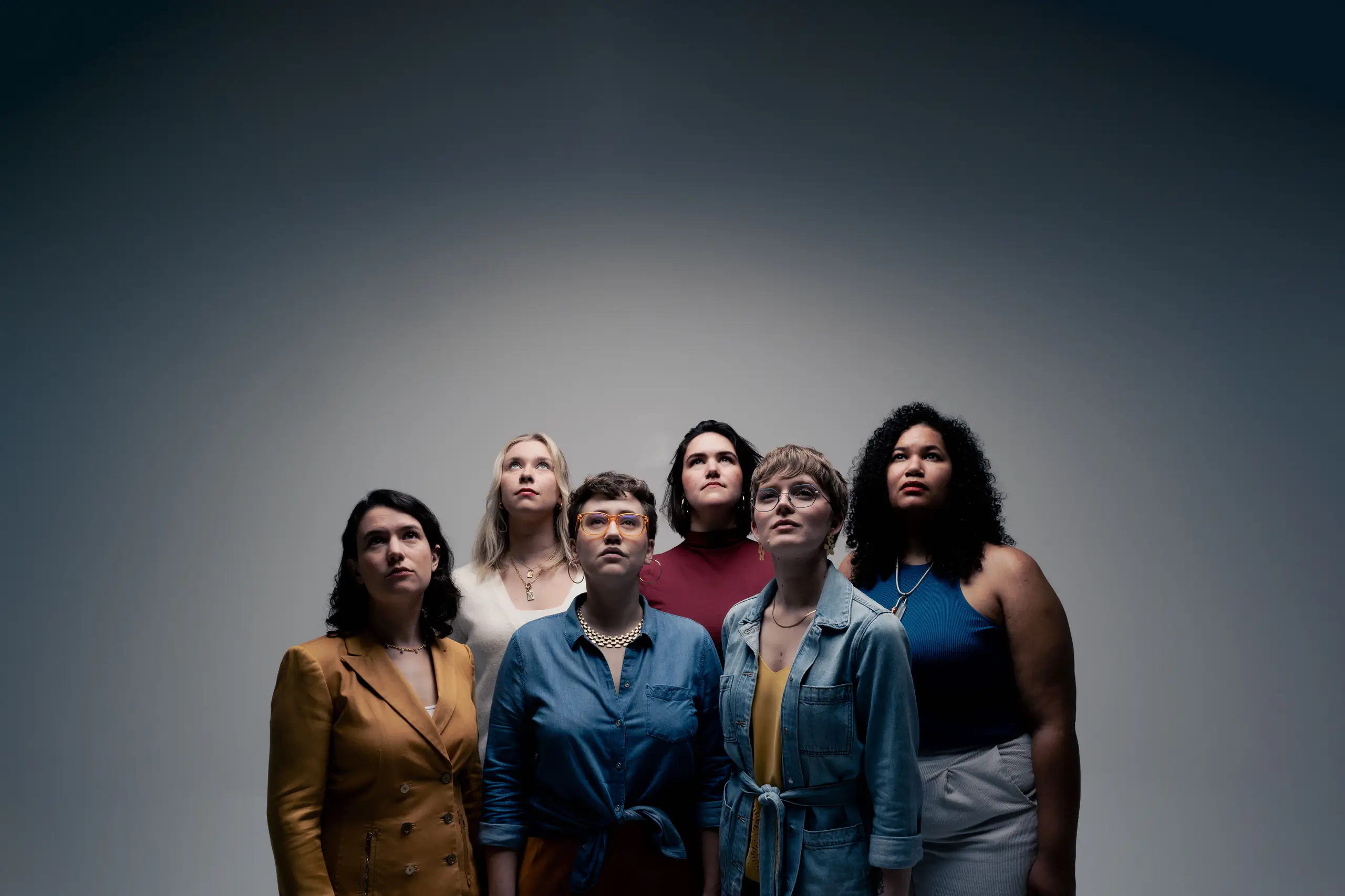 The six women who make up the group Lyyra stand in front of a gray background.