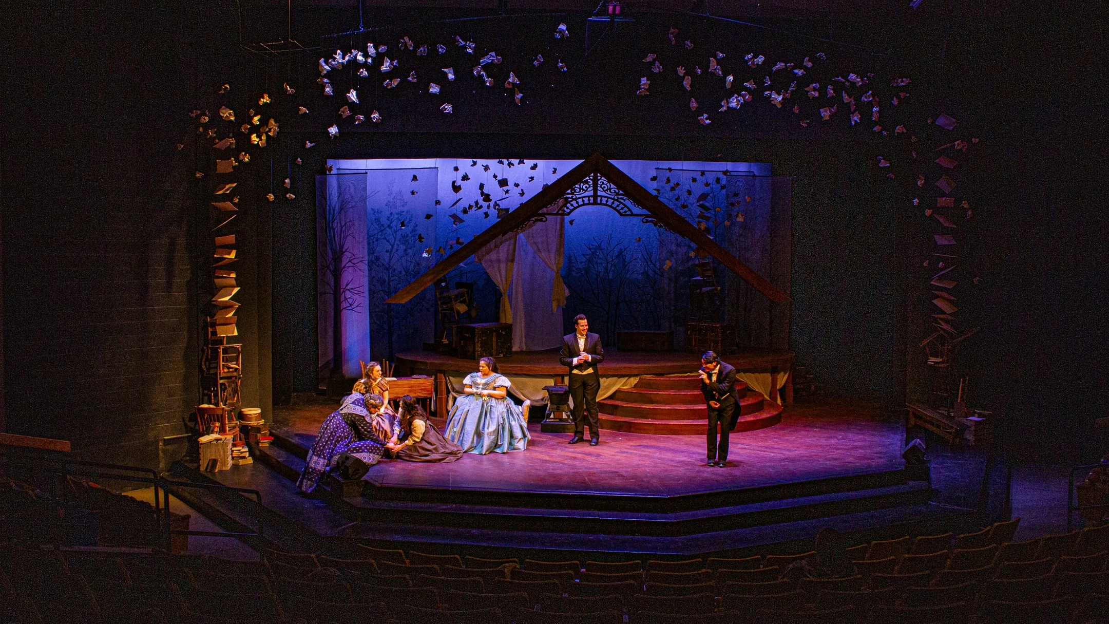 Four individuals performing on stage at a theatre