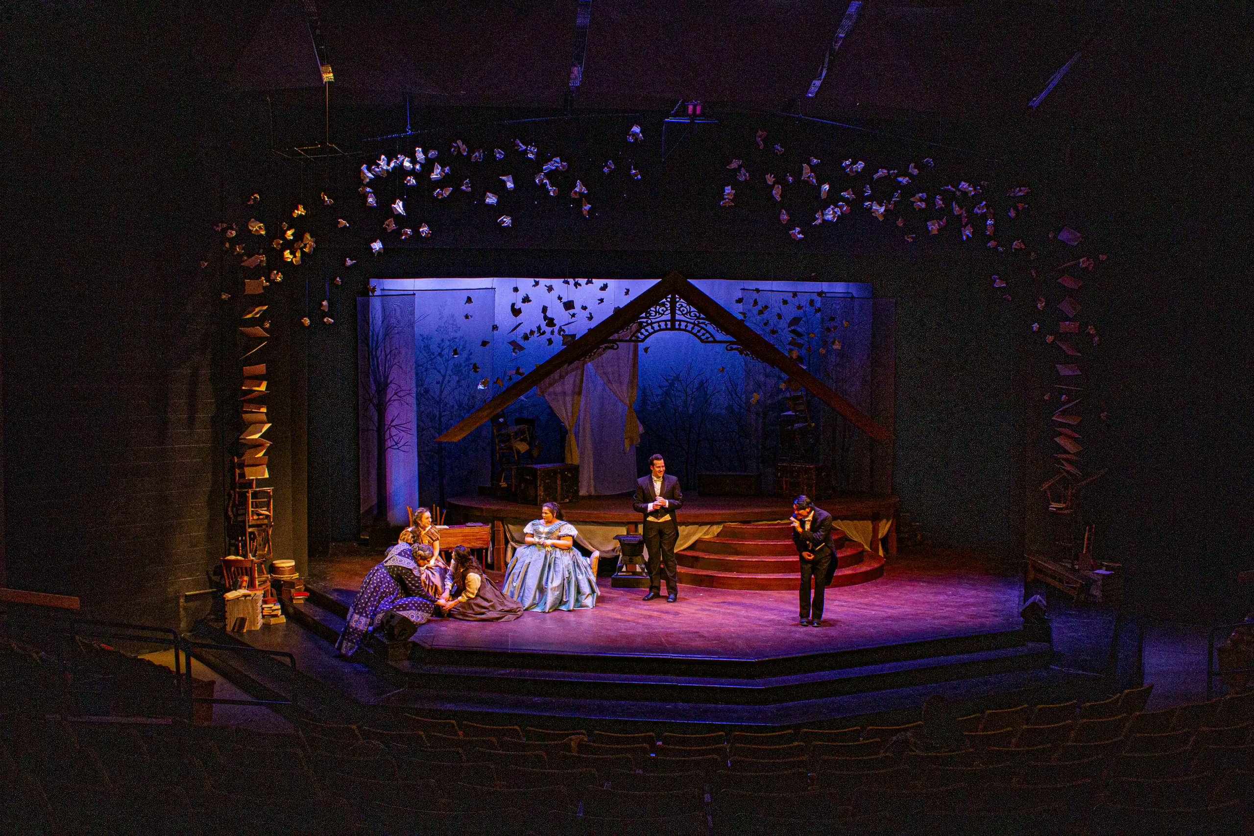 Four individuals performing on stage at a theatre